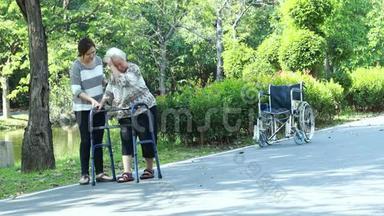 亚洲老年妇女在膝关节手术后的康复过程中使用助行器，年轻的护理人员协助让老人安心